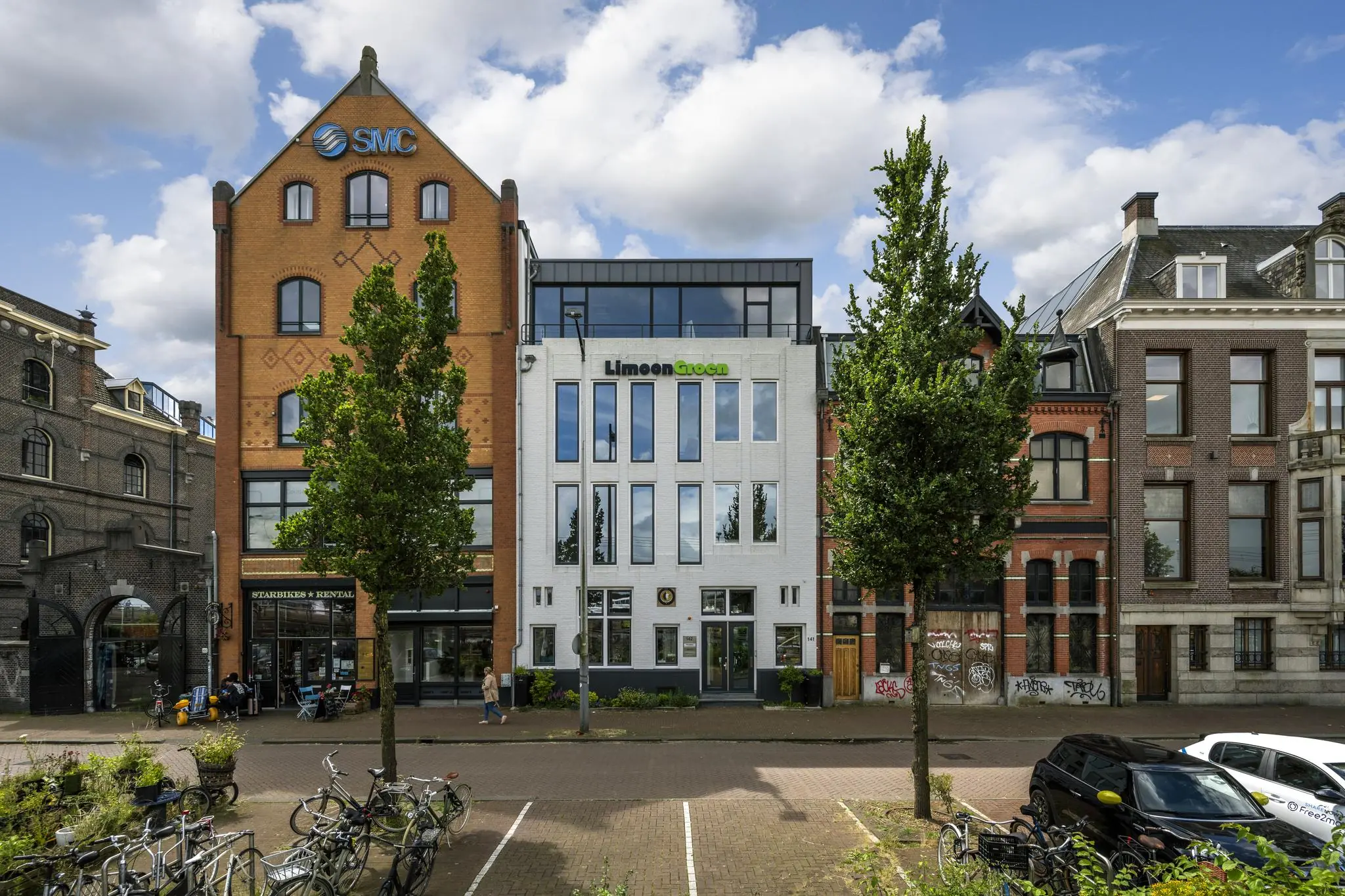 Voorgevels van diverse kantoorpanden aan de De Ruijterkade in Amsterdam, waaronder SMC en LimoenGroen.